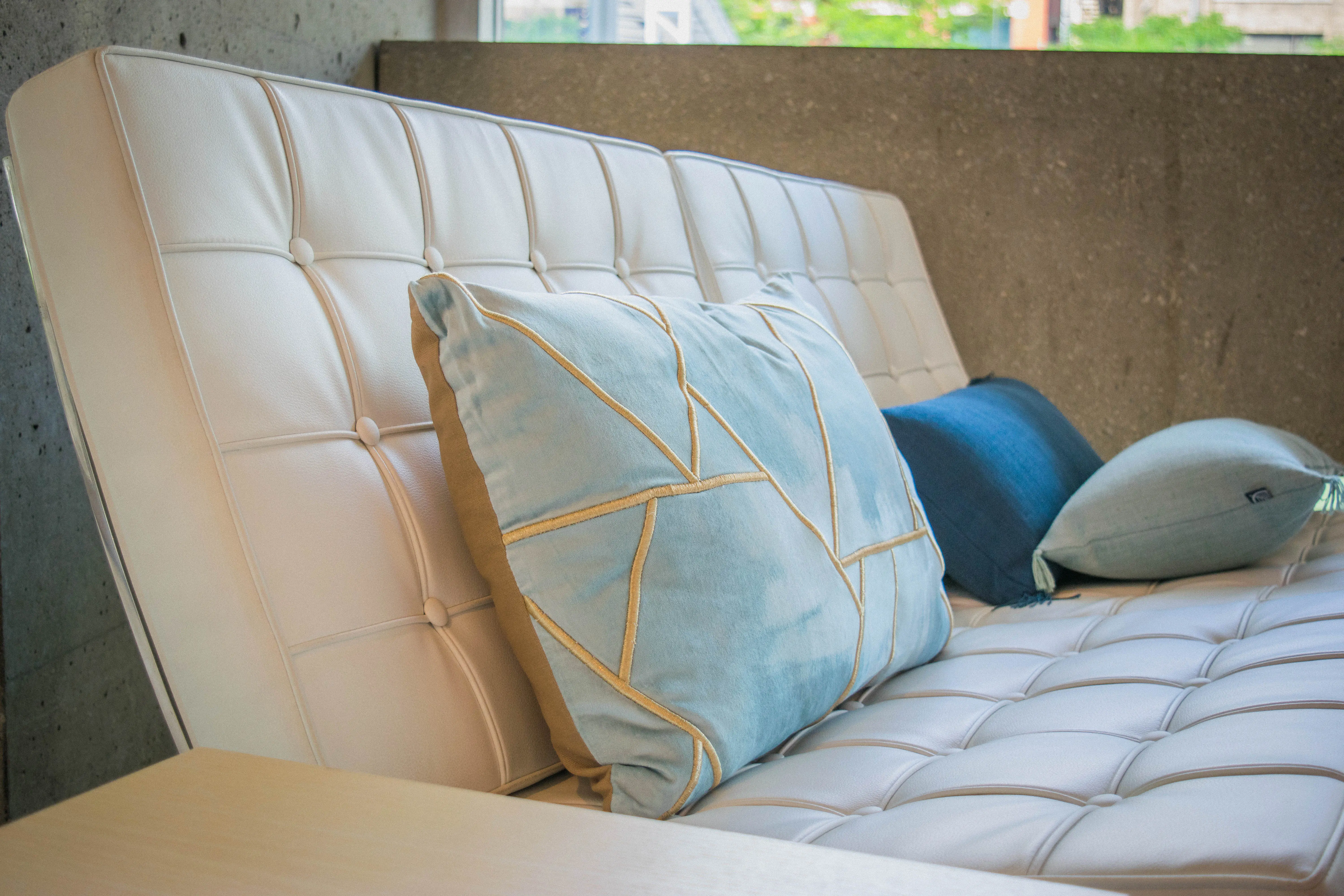 Coussin velours géométrique - Bleu et bronze utilisé dans le cadre de la réalisation Fauteuil Scarpino Blanc