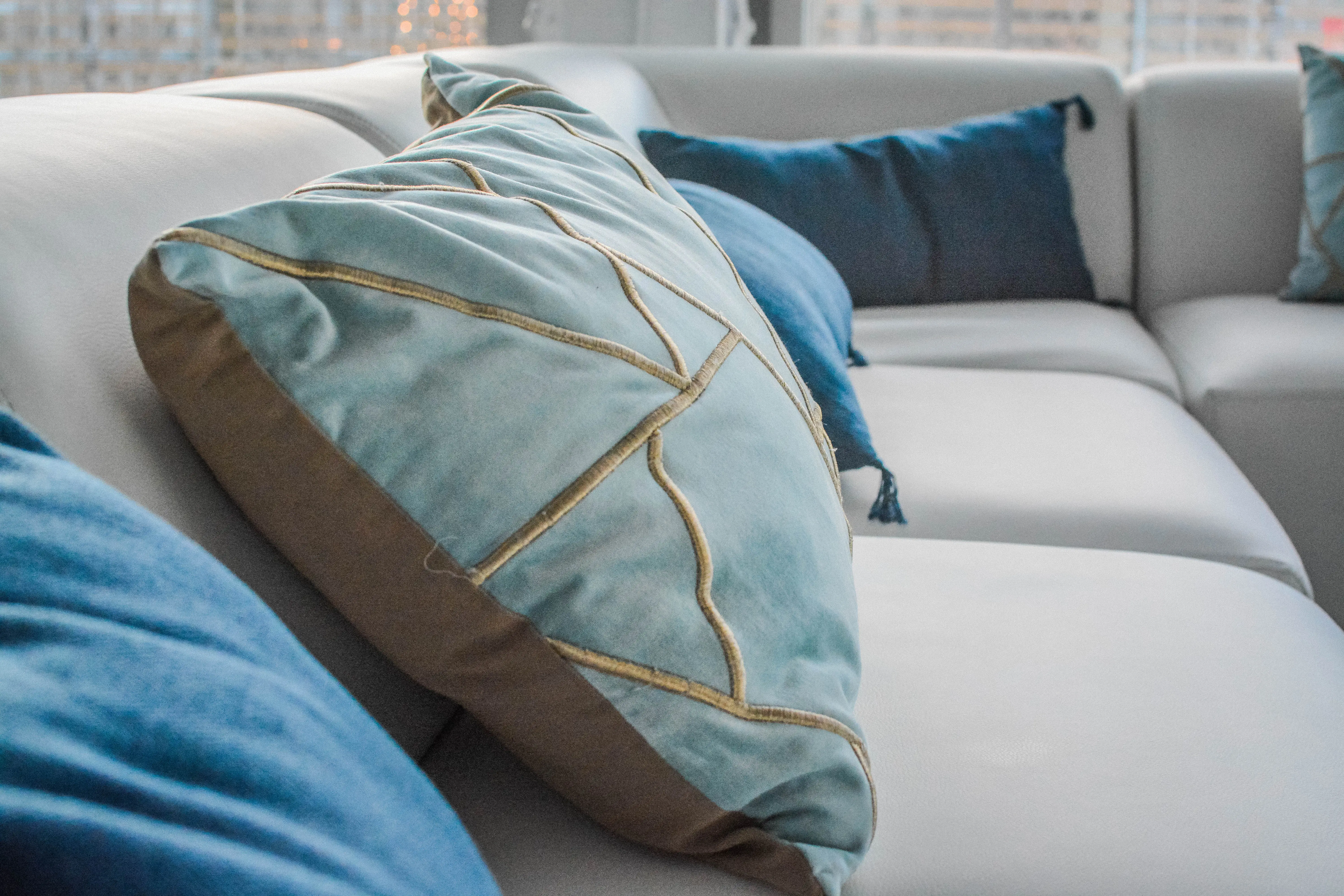 Coussin velours géométrique - Bleu et bronze utilisé dans le cadre de la réalisation Pub Coussin Sofa Fidji